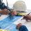 Person's engineer Hand Drawing Plan On Blue Print with architect equipment, Architects discussing at the table, team work and work flow construction concept.